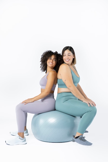 Foto vollschussfrauen, die auf gymnastikball sitzen