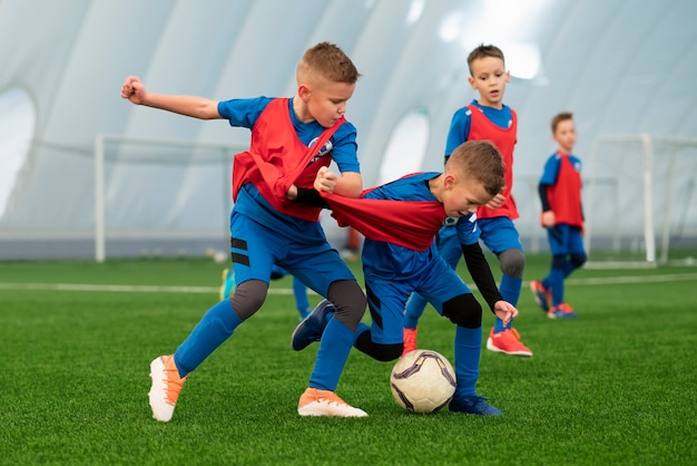 Vollschusskinder, die Fußball spielen