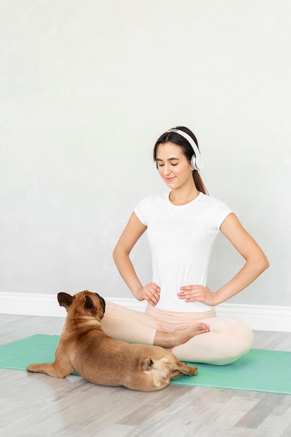 Foto vollschussmädchen auf yogamatte mit hund