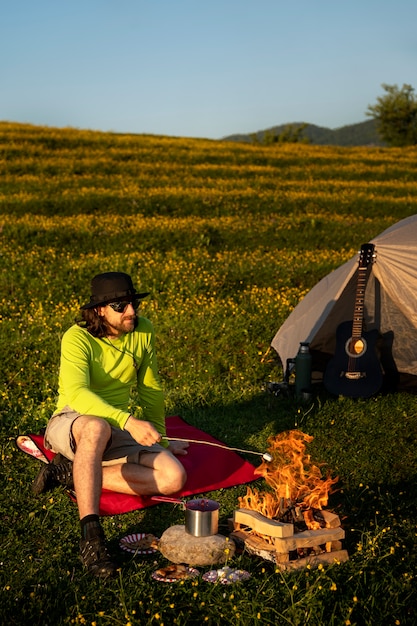 Foto vollschussmann, der am feuer sitzt