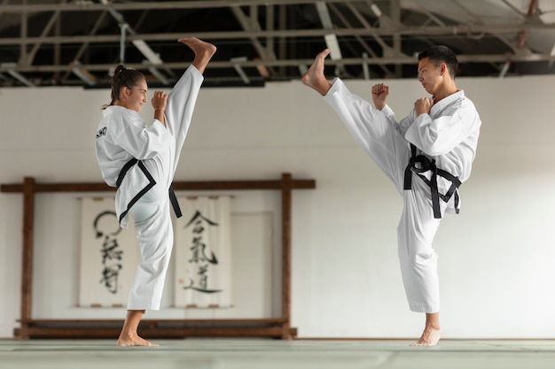 Foto vollständige aufnahme asiatischer menschen, die taekwondo üben