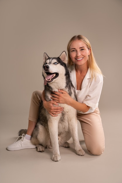 Vollständige Aufnahme einer Frau mit Hund im Studio