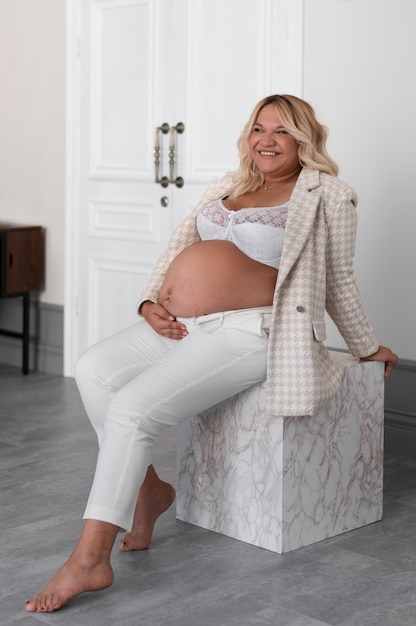 Foto vollständige aufnahme einer schwangeren frau, die im studio posiert