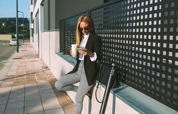 Foto vollständige länge einer frau, die am handy sitzt