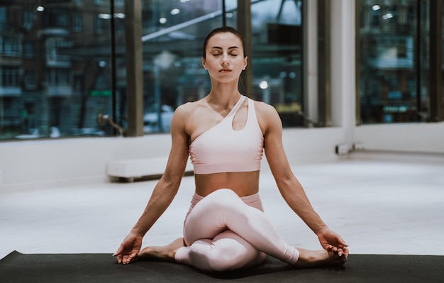 Vollständige Länge einer Frau, die im Fitnessstudio meditiert