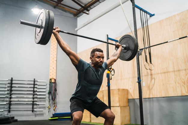 Foto vollständige länge eines mannes, der im fitnessstudio trainiert