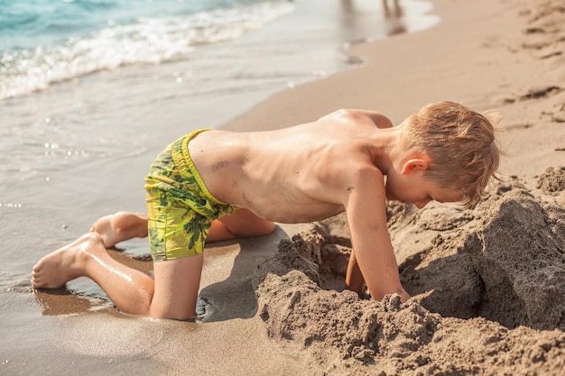 Vollständige Länge von hemdlosem Jungen am Strand