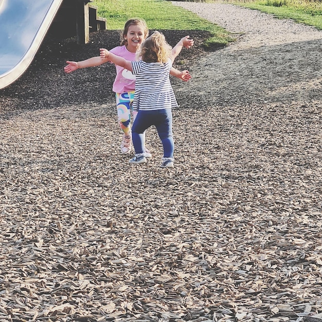 Foto vollständige länge von kindern, die auf dem spielplatz spielen