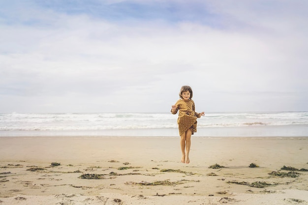 Vollständige Länge von Mädchen, das am Strand springt