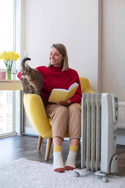 Foto vollständige smiley-frau mit katze und buch