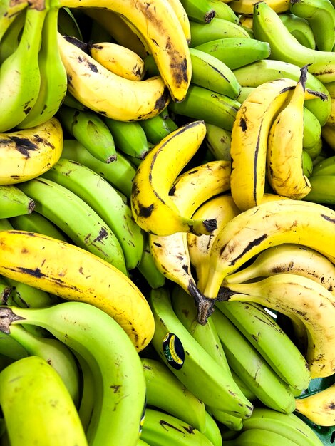 Vollständiger Hintergrund vieler frischer gelber Bananen, die auf einem Marktstand platziert sind