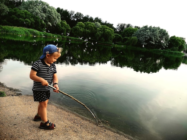 Foto vollständiger junge, der im see steht