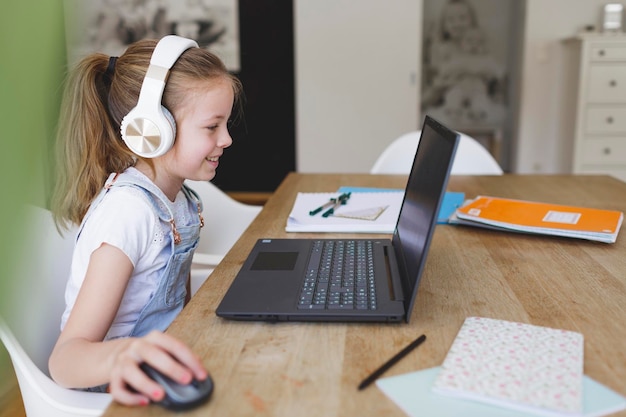 Vollständiges Mädchen mit Laptop auf dem Tisch