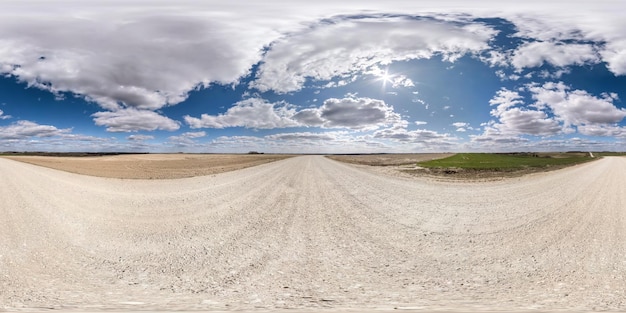 Vollständiges nahtloses sphärisches hdr-Panorama 360-Grad-Winkelansicht auf weißer Sandkiesstraße zwischen Feldern am Frühlingstag mit fantastischen Wolken in gleichrechteckiger Projektion, bereit für VR-Virtual-Reality-Inhalte