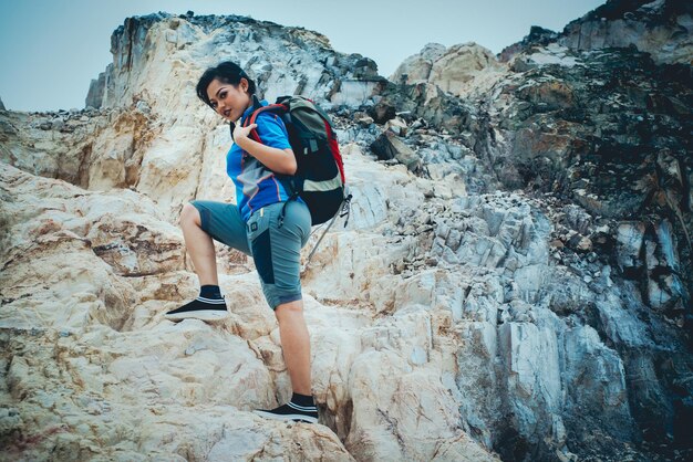 Foto vollständiges porträt einer frau, die auf einem felsen steht