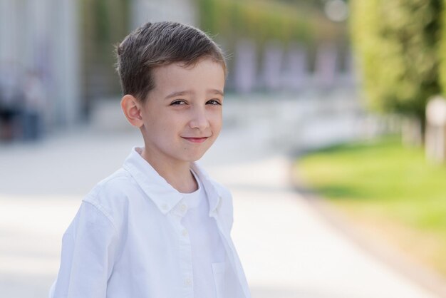 Vollständiges Porträt eines 5-jährigen Jungen in einem weißen Hemd mit den Händen in den Taschen