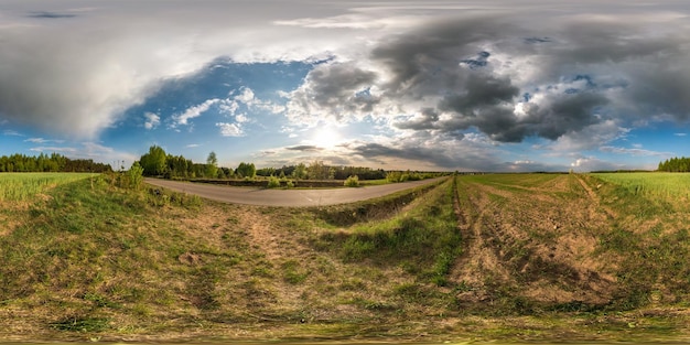 Vollständiges sphärisches nahtloses Panorama 360-Grad-Winkelansicht auf verkehrsfreier Asphaltstraße zwischen Gassen und Feldern mit fantastischen Wolken in equirectangulärer äquidistanter Projektion VR-AR-Inhalt