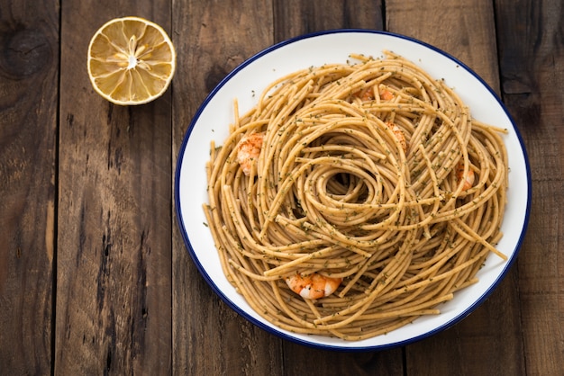 Vollweizenspaghettis mit Garnele auf Holz