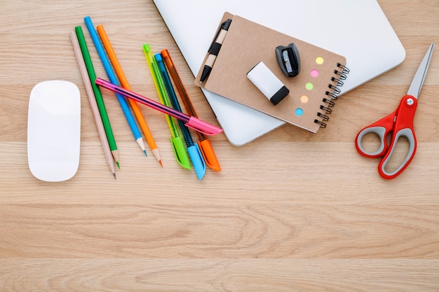 Volta ao conceito de escola com material escolar na mesa de madeira.