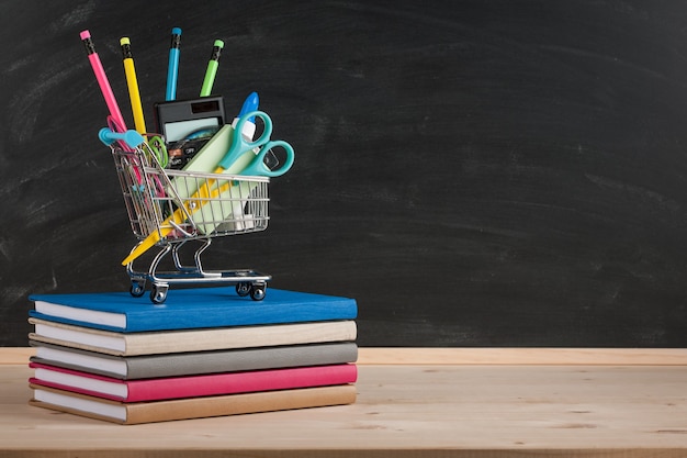 Volta ao conceito de escola com material escolar no fundo do quadro-negro