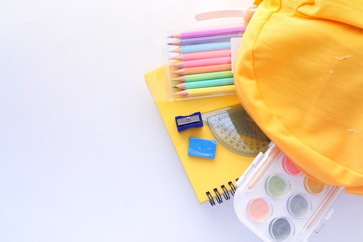 Foto volta ao conceito de escola com mochila amarela e fornecedores de escola na mesa.