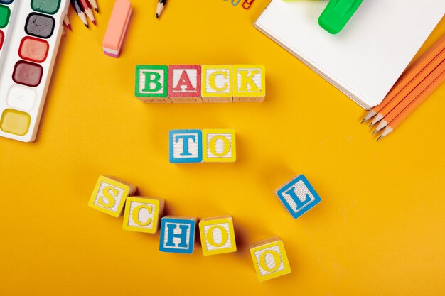 Volta ao conceito de escola. Cubos alfabéticos de madeira coloridos