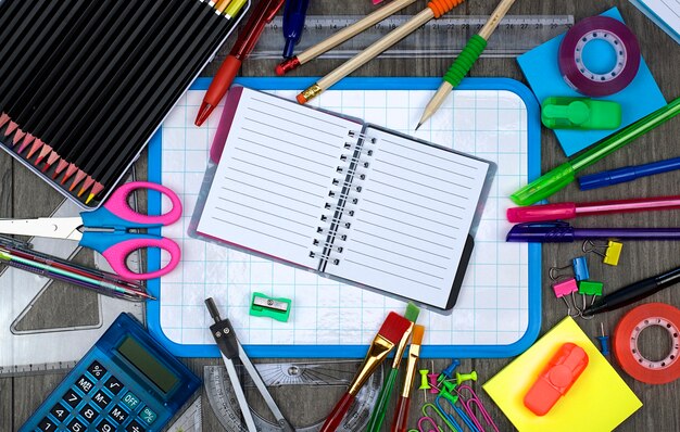 Foto volta ao conceito de escola: escritório e material escolar com um notebook em um fundo de madeira