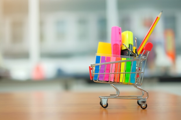 Foto volta para a escola e conceitos de educação com carrinho de compras, lápis, marcador