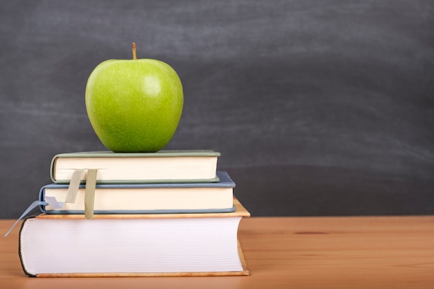 Voltar ao fundo da escola com livros, lápis e uma maçã na mesa da escola.