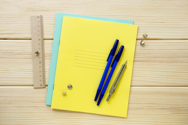 Voltar para a escola plana lay. Artigos de papelaria em um fundo claro de madeira, vista superior