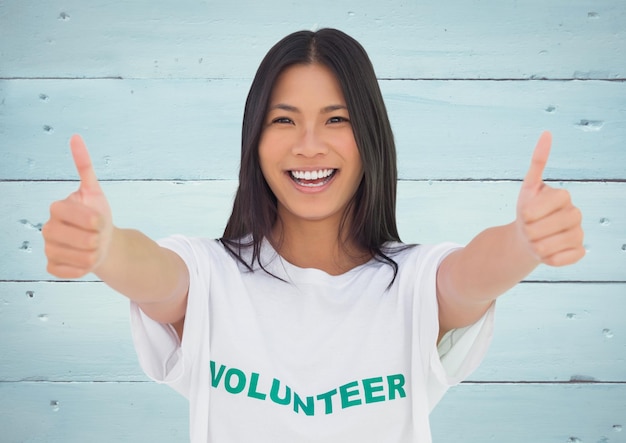 Voluntaria sonriente que muestra los pulgares para arriba