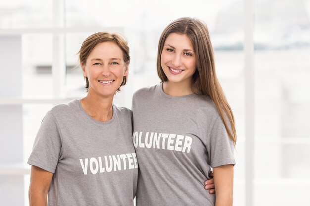 Voluntarias sonrientes que se abrazan