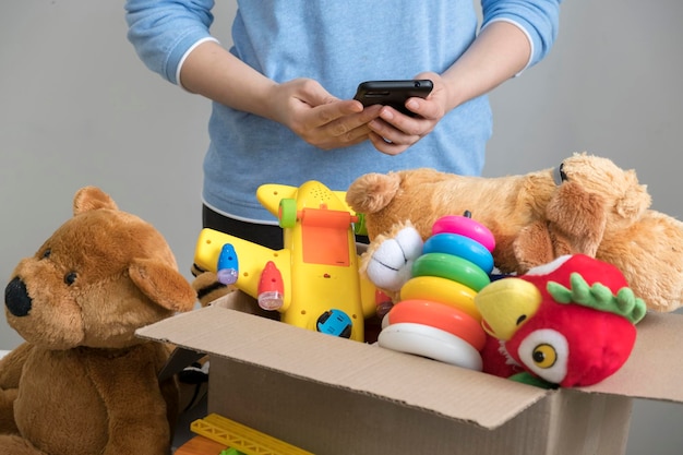 Foto voluntario con caja de donación con juguetes viejos