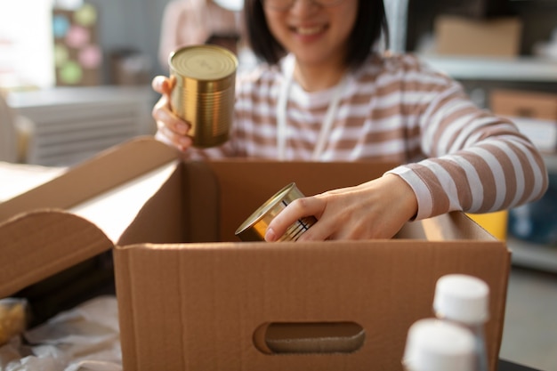 Foto voluntário colocando doações de alimentos em caixas para caridade