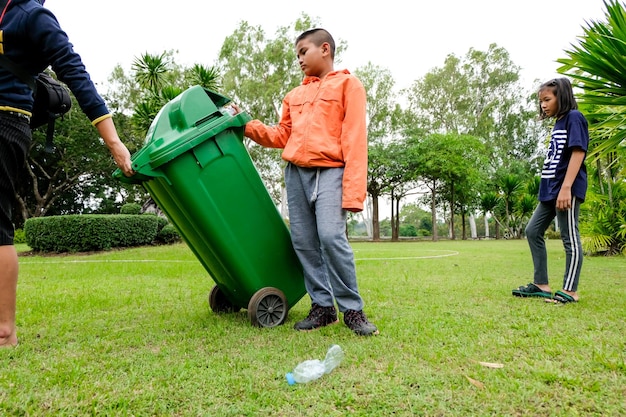 Foto voluntario con el contenedor de basura en el campo