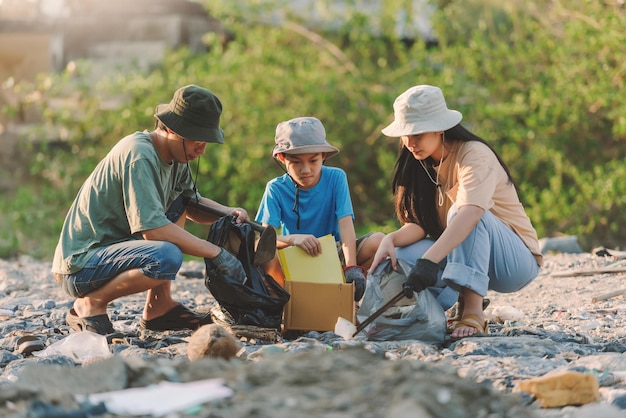 Voluntário de conservação do ambiente familiar asiático ajuda a manter e limpar lixo plástico e espuma na área de praia e floresta de mangueconceito de voluntariado