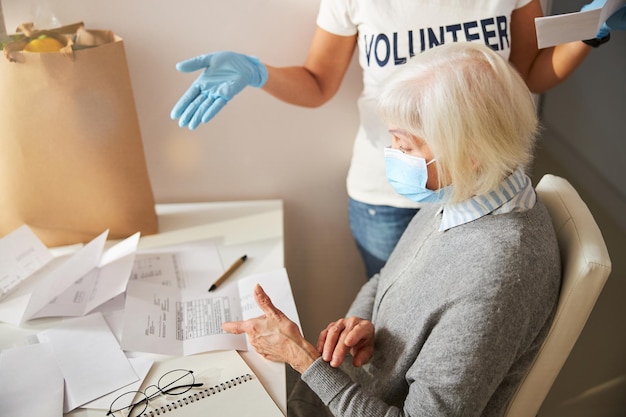 Voluntário e pensionista dando sentido às contas de serviços públicos