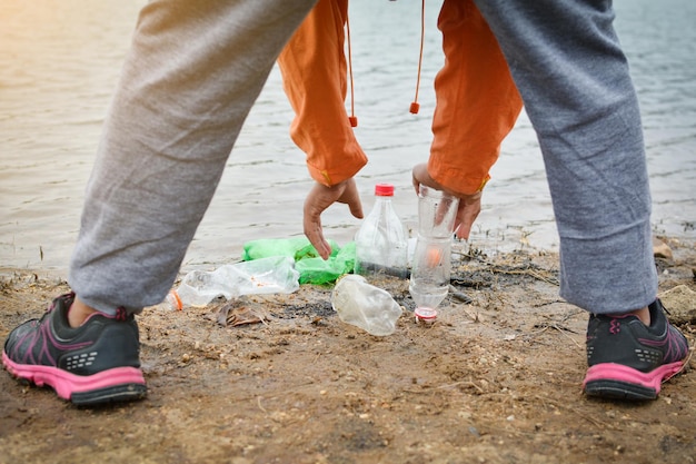 Voluntário limpando a beira de um lago na floresta