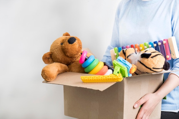 Voluntario masculino con una caja de donaciones con juguetes viejos