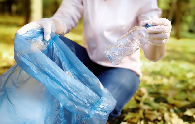 Foto voluntário pegar o lixo e colocá-lo em saco de lixo biodegradável no exterior.