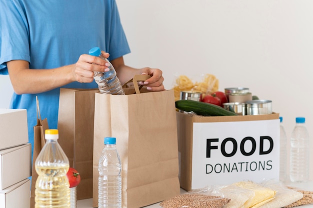 Voluntario preparando bolsa de comida para donación.