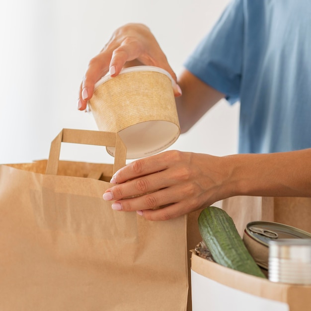 Foto voluntario preparando bolsa de donación con comida.