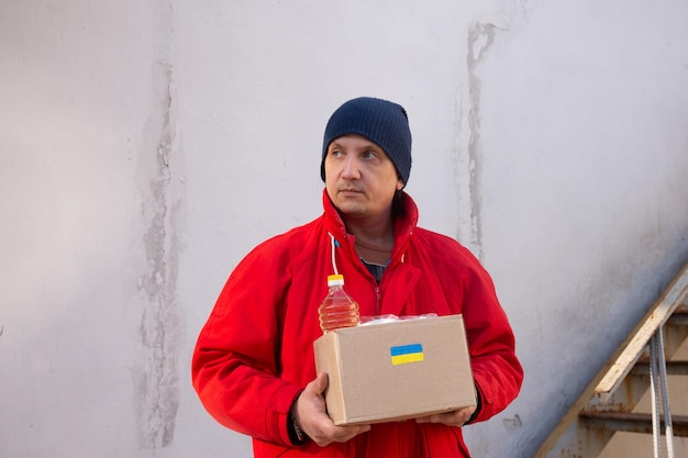 Voluntario preparando caja de comida para refugiados de guerra ucranianos ayuda humanitaria y concepto de ayuda