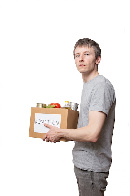 Voluntário, segurando alimentos na caixa de doação