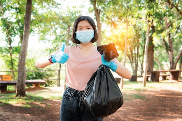 Voluntario sosteniendo basura plástica Limpie para eliminar los desechos adecuadamente