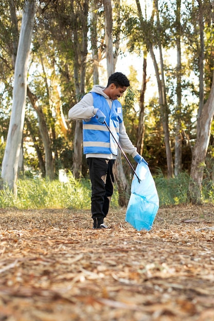 Foto voluntario de tiro completo recogiendo basura