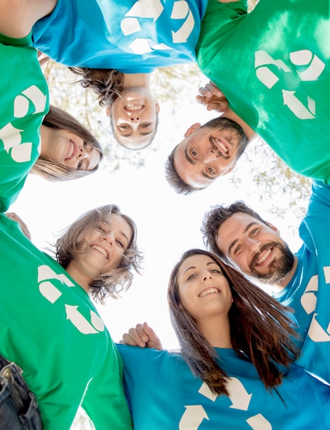 Voluntarios abrazándose en círculo y sonriendo