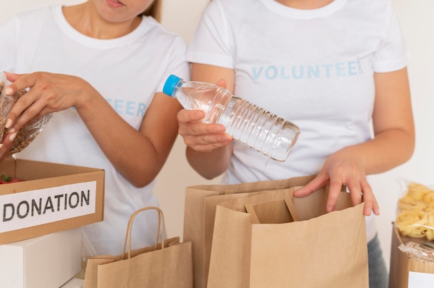 Voluntários colocando comida em sacolas para doação