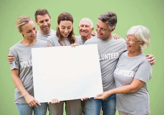 Voluntários com grande cartão em branco contra fundo verde