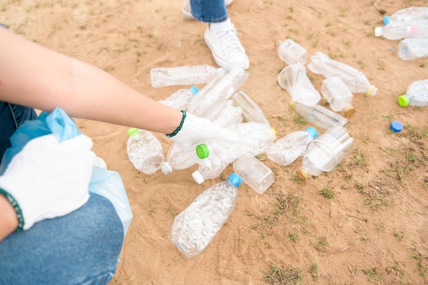 Voluntários da comunidade jovem asiática usando sacos de lixo para limpar a natureza